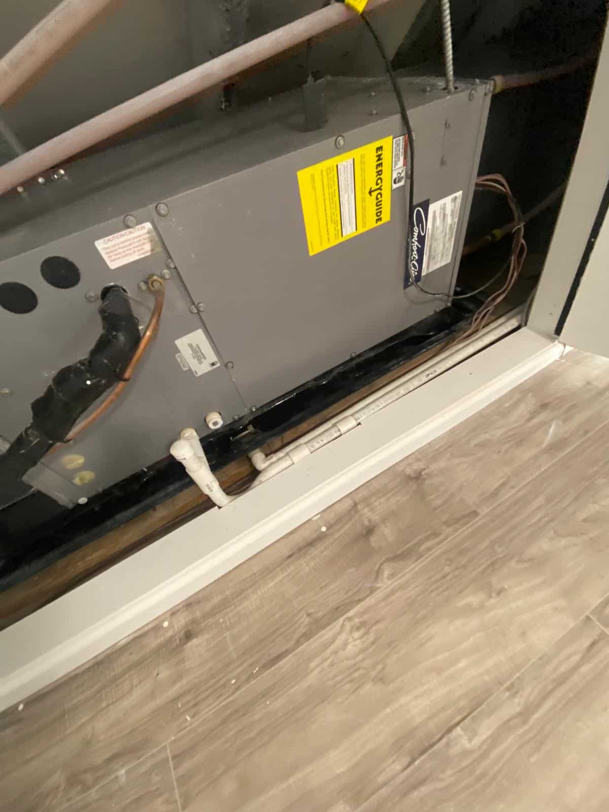 Basement electrical panel adjacent to a plumbing riser in an older Brooklyn building